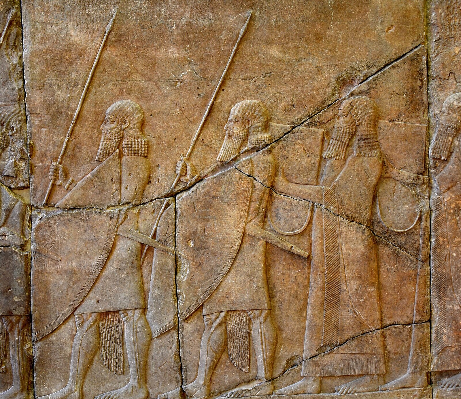 Alabaster bas-relief, a procession of 2 Assyrian soldiers and 2 musicians carrying rectangular drums with drag ropes. Reign of Sennacherib, 704-681 BCE